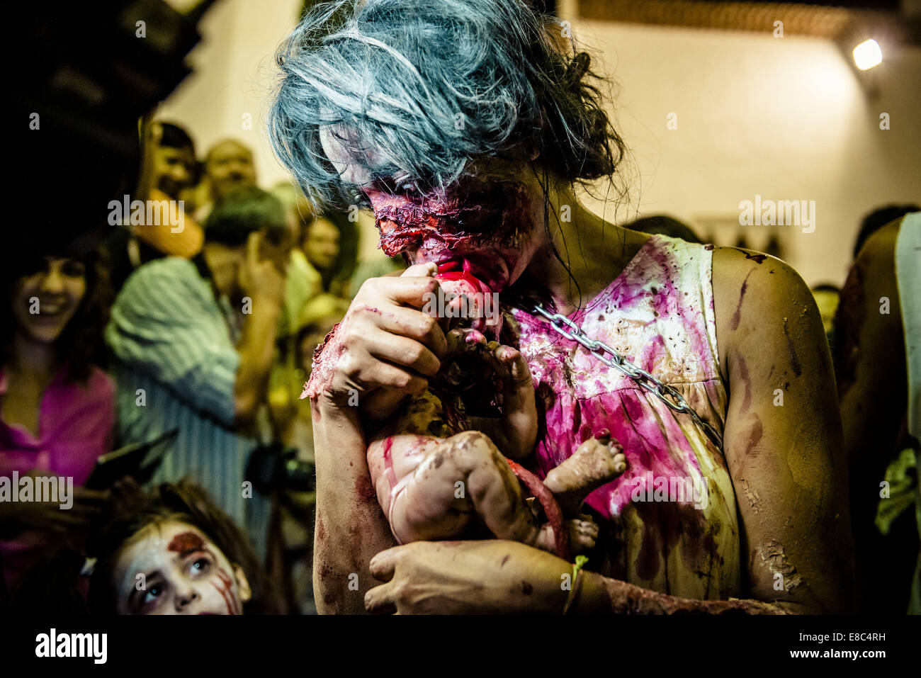 Sitges, Spain. 4th Oct, 2014. A woman in a zombie costume licks at her zombie puppet hanging on a umbilical cord at the Sitges Zombie Walk 2014 Credit:  Matthias Oesterle/ZUMA Wire/ZUMAPRESS.com/Alamy Live News Stock Photo