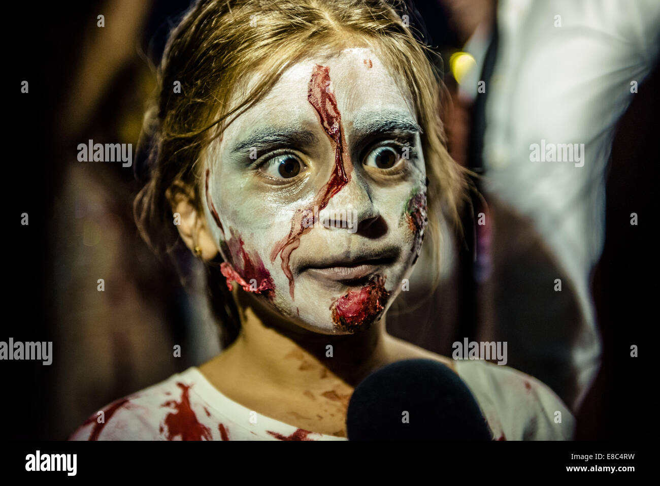 Sitges, Spain. 4th Oct, 2014. A girl made-up as a zombie gives an TV interview during the Sitges Zombie Walk 2014 Credit:  Matthias Oesterle/ZUMA Wire/ZUMAPRESS.com/Alamy Live News Stock Photo