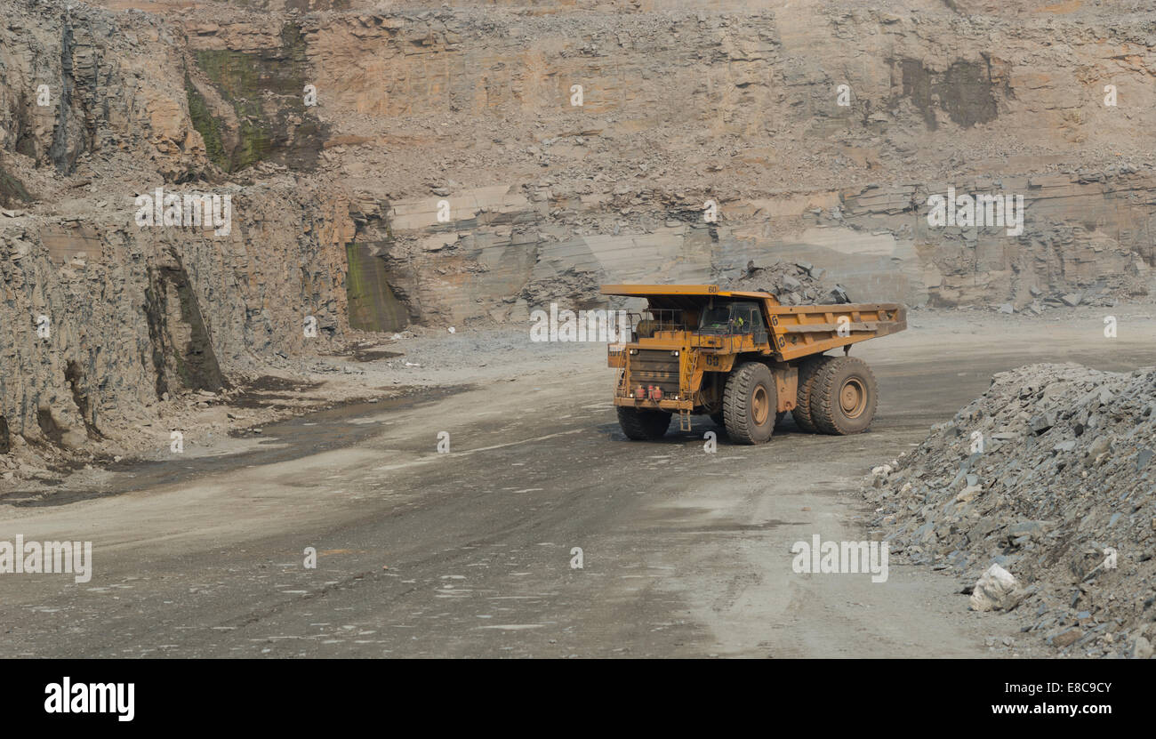 A large caterpillar mining truck hauls ore in a large open cast copper mine in Africa. Stock Photo