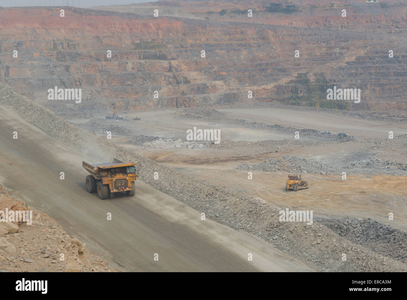 industrial landscape, a Caterpillar mining truck drives down a haulage ramp into a large open-cast African copper mine. Stock Photo