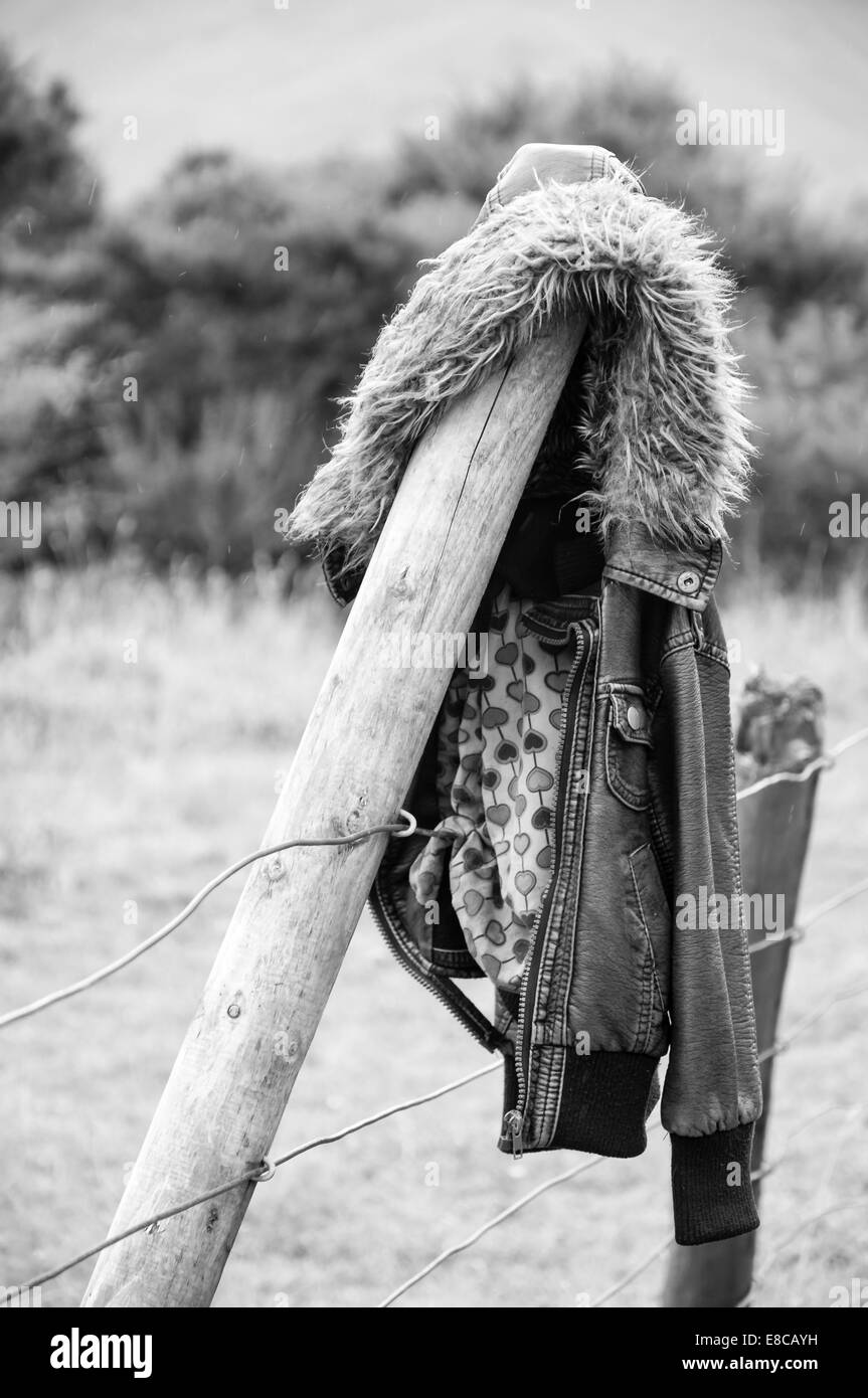 vintage leather jacket hanging over a fence pole in the highlands Stock Photo
