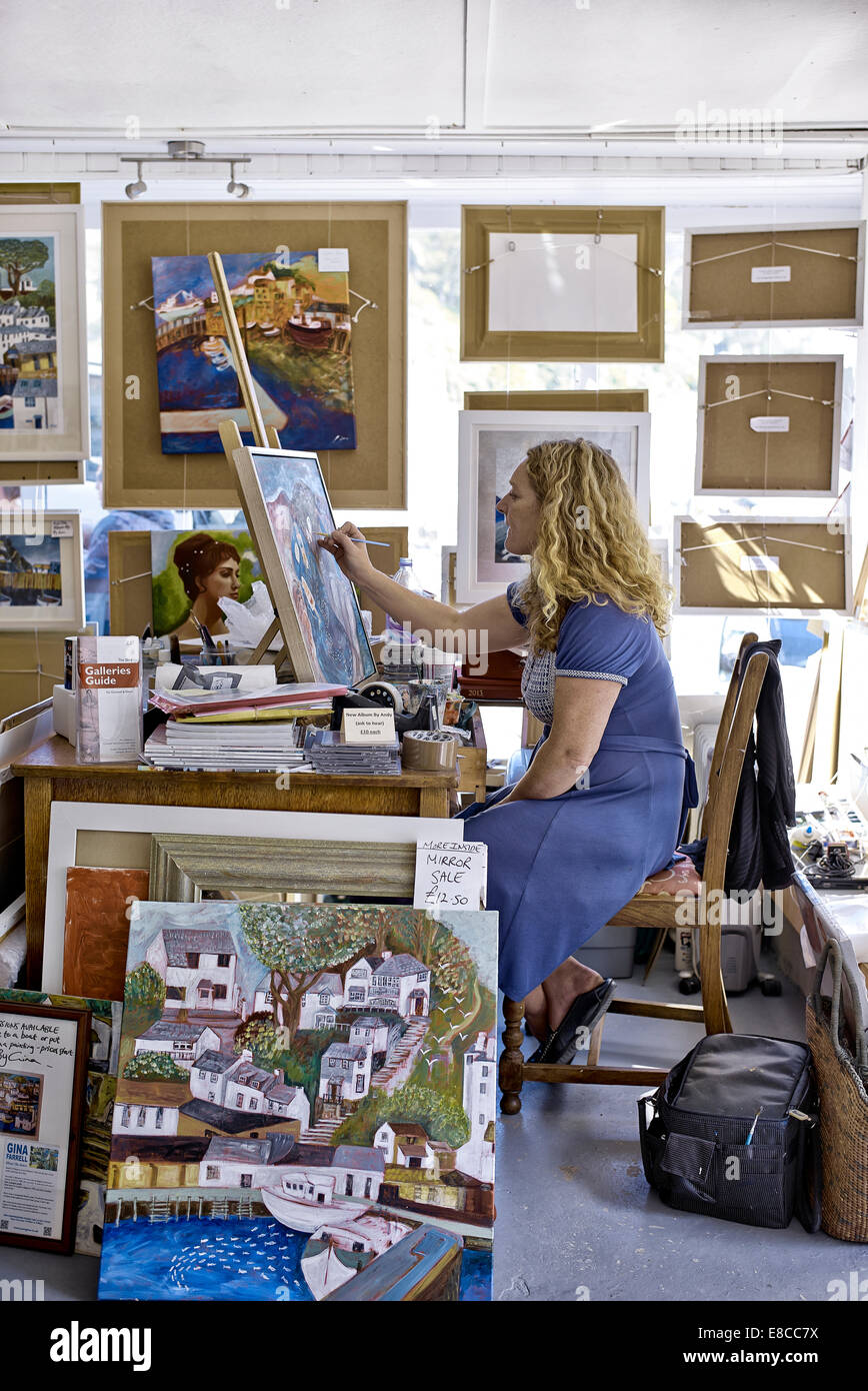 Woman artist painting. Gina Farrell at work in her studio. Polperro Cornwall England UK Stock Photo