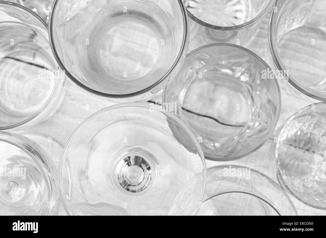 High angle shot of assorted glassware forming an abstract pattern. Horizontal format on a white wood table, with shallow depth o Stock Photo