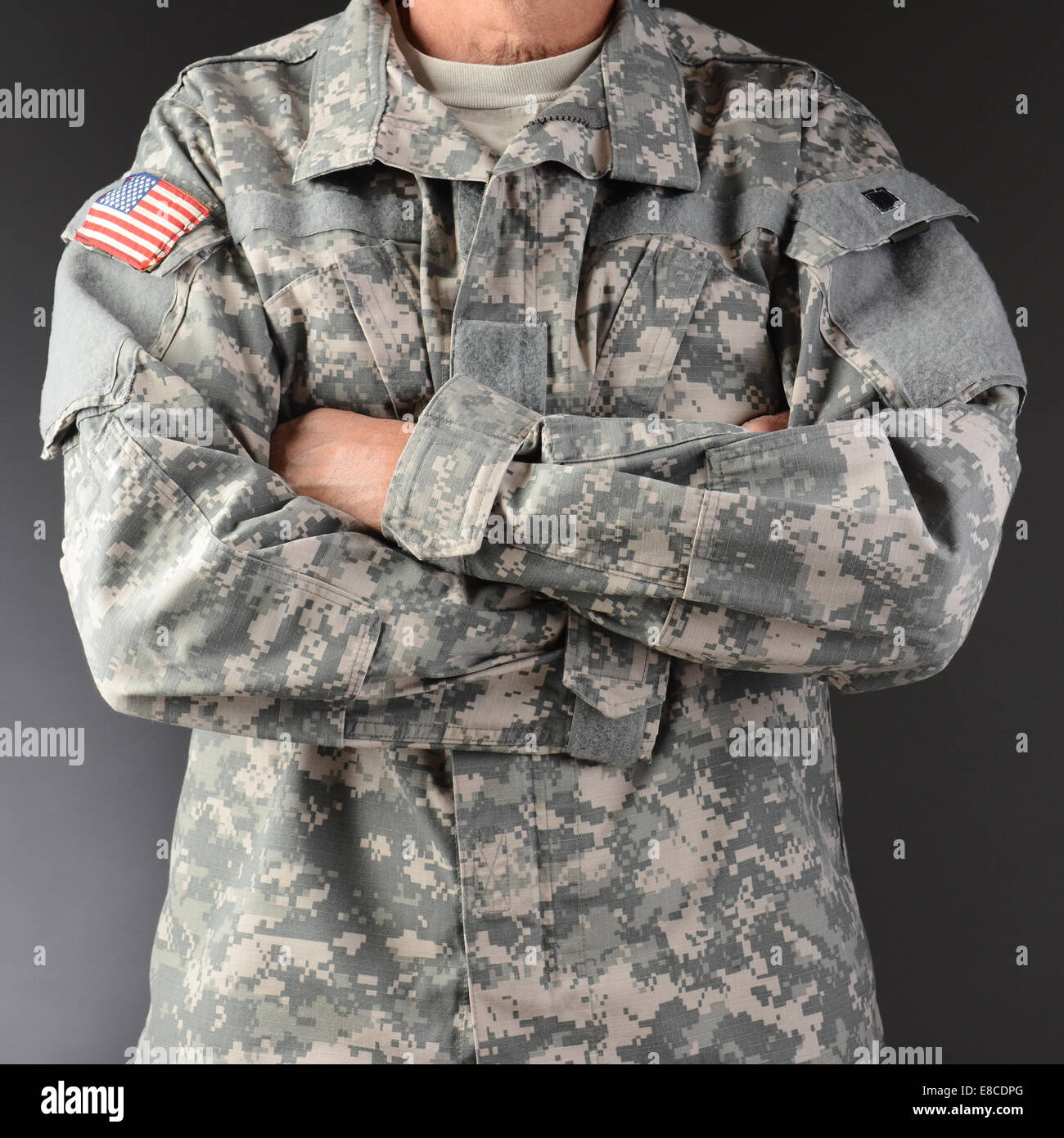 Closeup of a soldier wearing camouflage fatigues with his arms folded. Square format, man is unrecognizable. Stock Photo