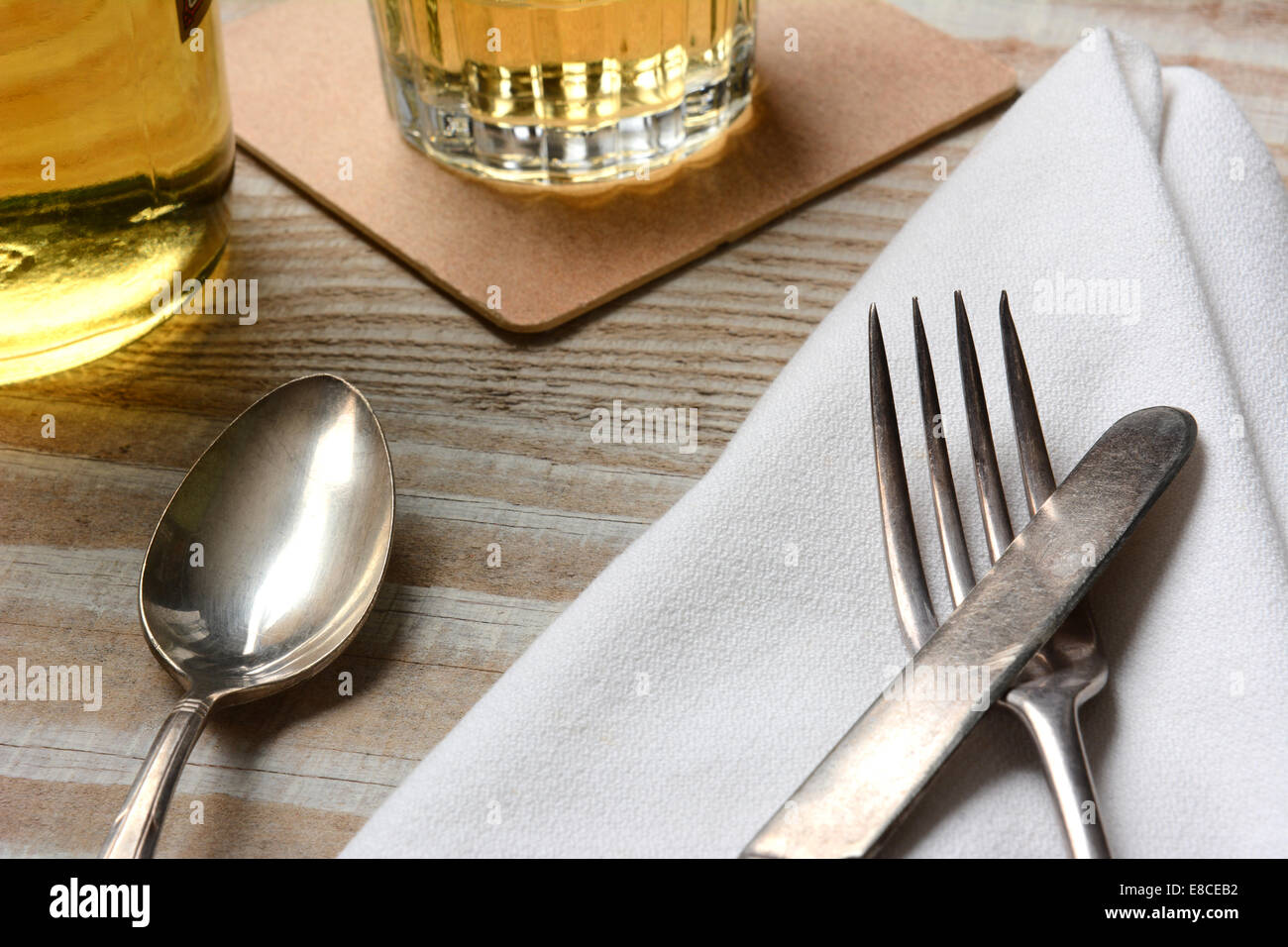 Closeup of a table setting. Old silverware, napkin and drinks on a ... Closeup of a table setting. Old silverware, napkin and drinks on a ...