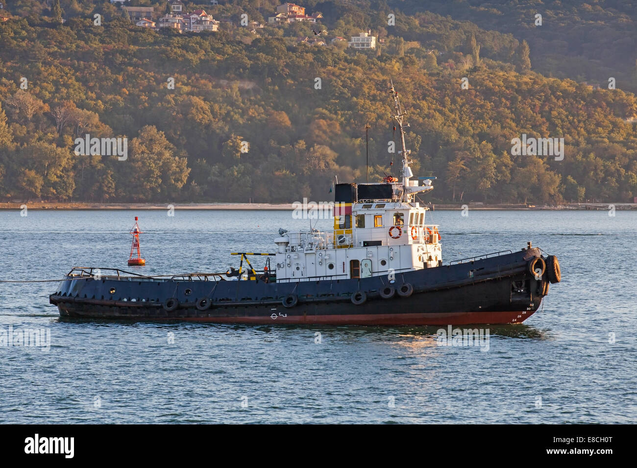 Black tug is underway on Black sea, Varna harbor, Bulgaria Stock Photo