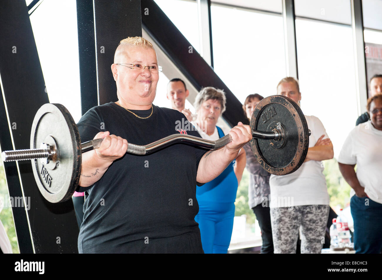 Senior female participant performing the strict curl setting a world record at sixty years of age. Stock Photo
