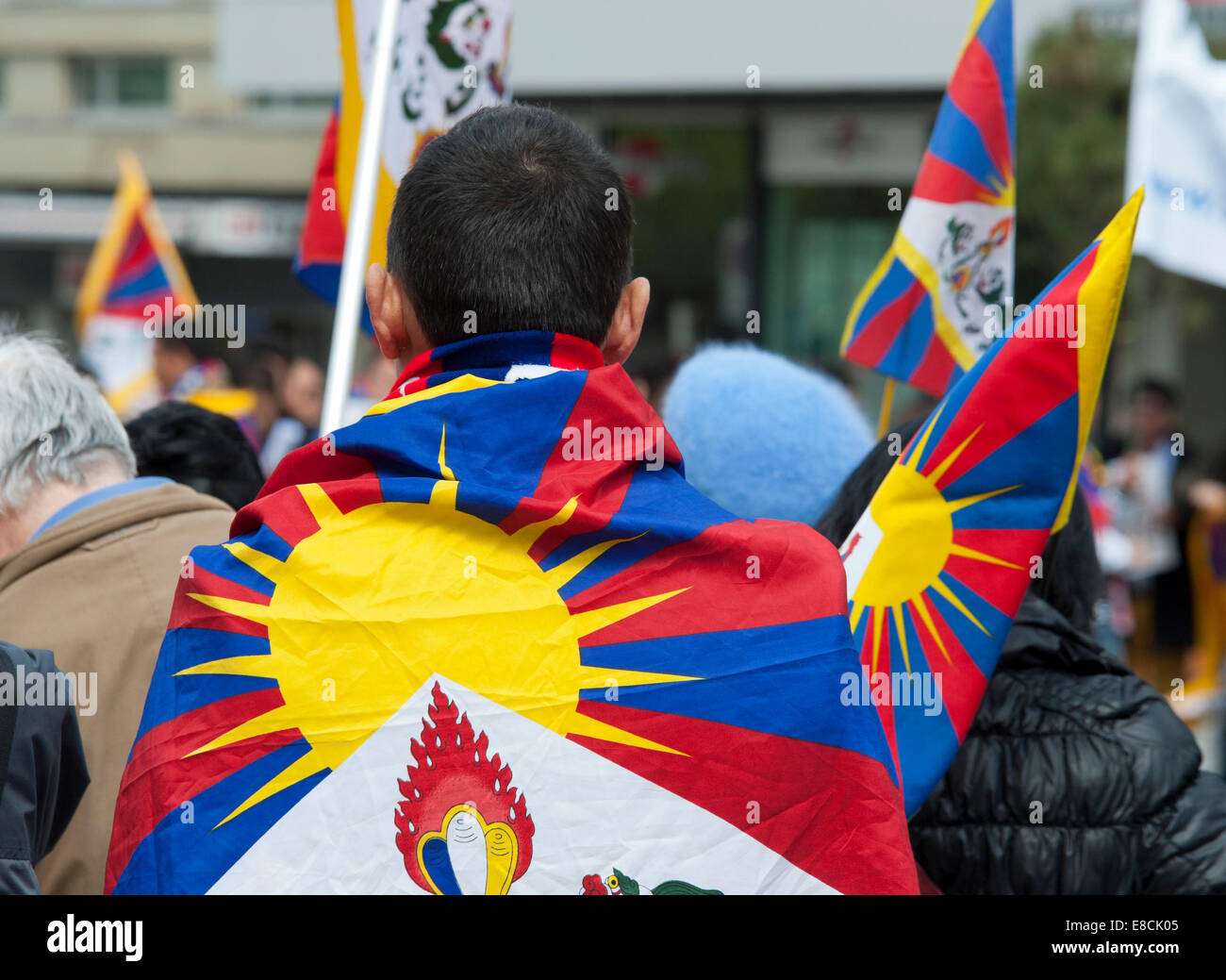 An exile Tibetan is showing his nation's colours at a protest rally in Bern, Switzerland. Stock Photo