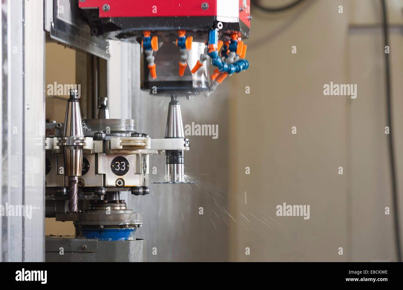 A CNC milling cutter is automatically changing its tooltip during production of a custom aluminum spare part Stock Photo