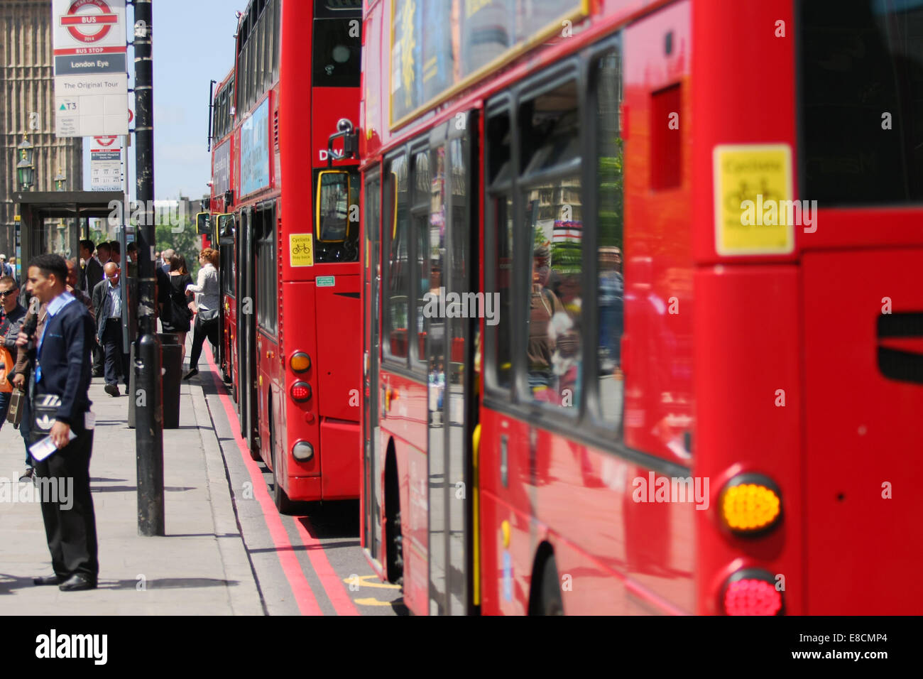 a-red-london-bus-waiting-at-a-bus-stop-while-passengers-disembark-stock