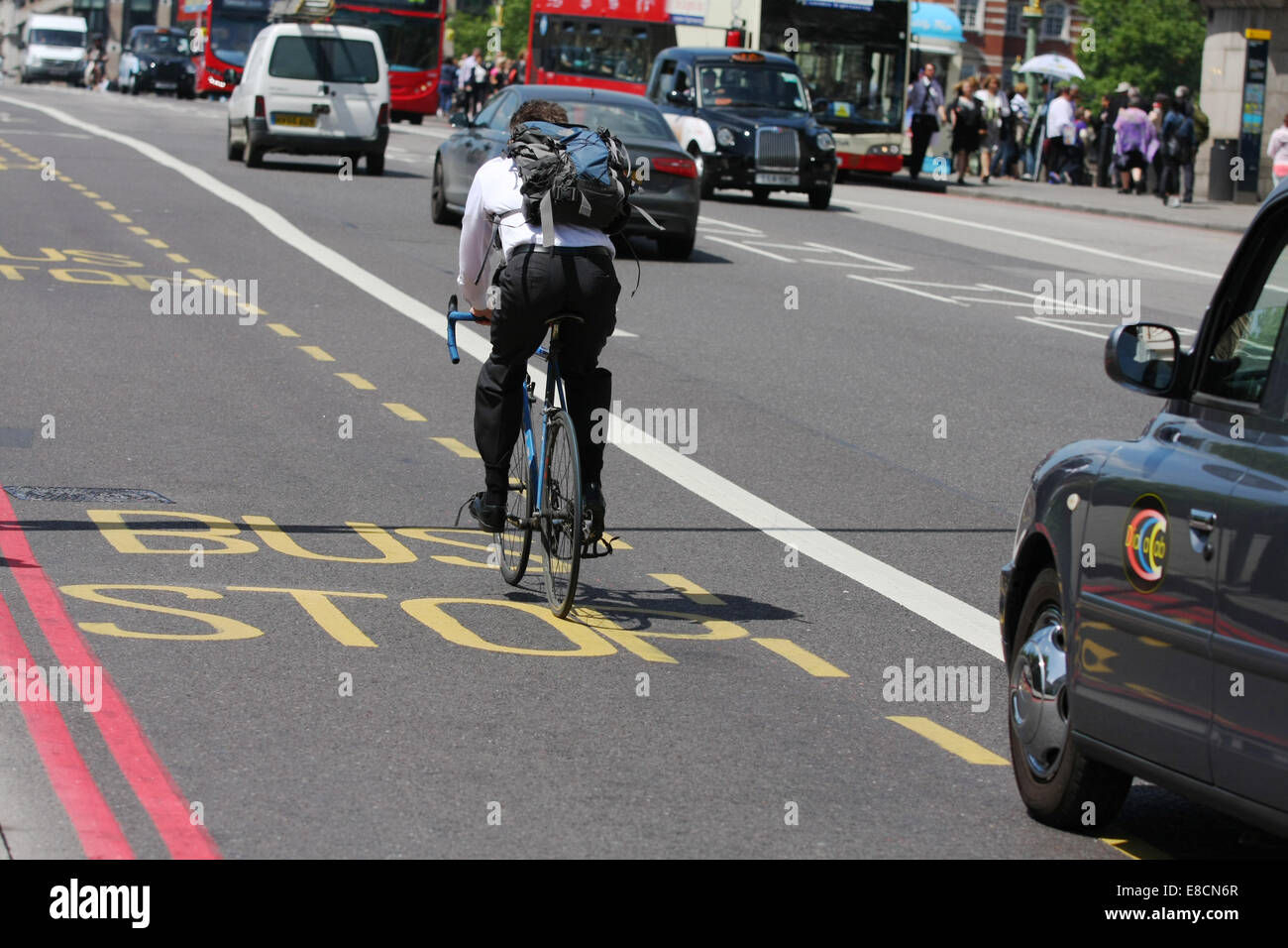 A taxi about to overtake a cyclist riding in a bus lane in London ...