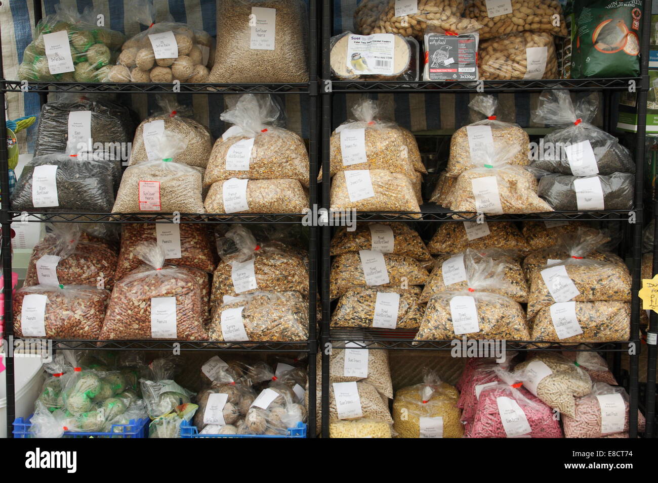 Bags of wild bird seed for sale outside a Derbyshire pet supplies shop, England, UK Stock Photo