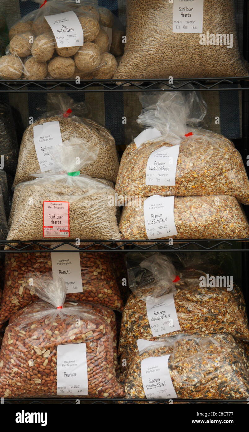 Bags of wild bird seed for sale outside a Derbyshire pet supplies shop, England, UK Stock Photo