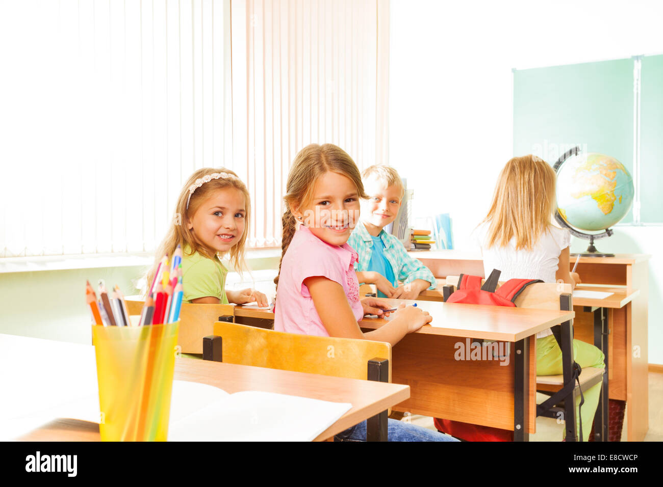 Children sitting at their school desks hi-res stock photography and ...