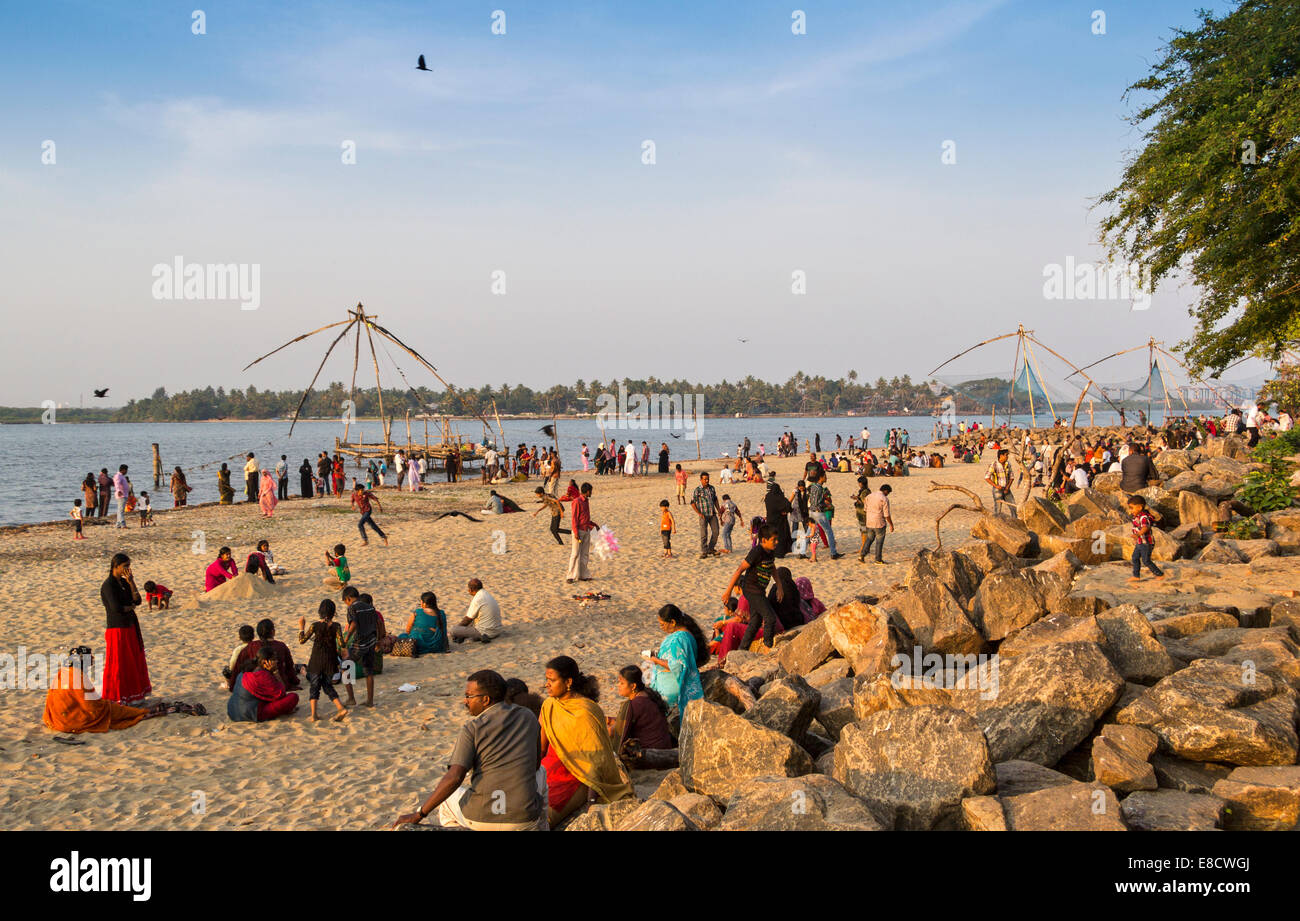 PORT COCHIN OR  KOCHI INDIA AND CHINESE FISHING NETS WITH PEOPLE ON THE BEACH Stock Photo