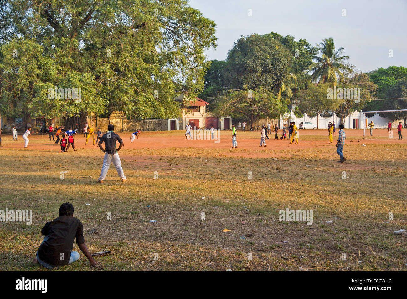 WATCHING A GAME OF CRICKET IN A PARK PORT KOCHI or COCHIN INDIA Stock Photo