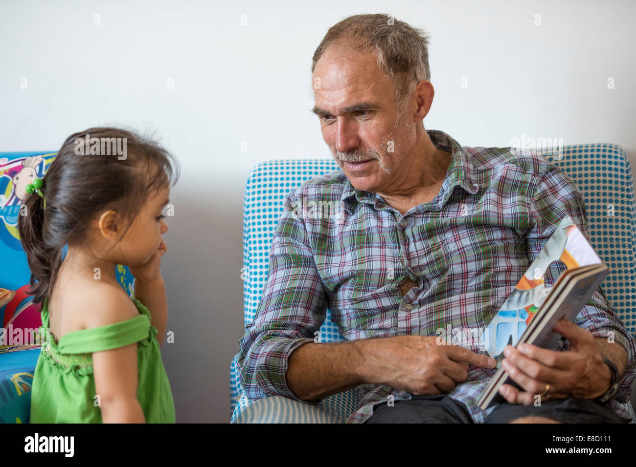 Grandparent reading to grandchild Stock Photo