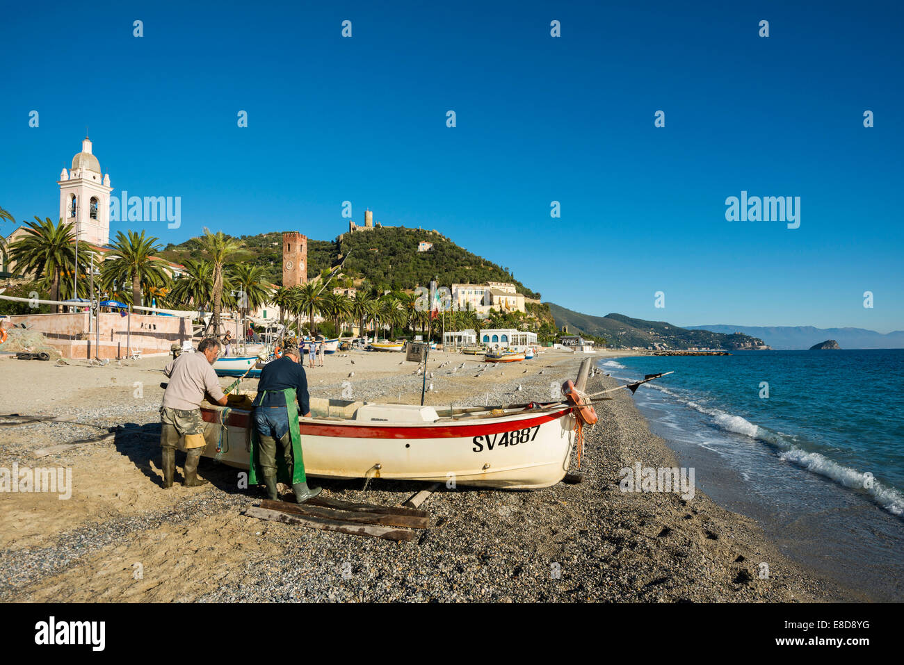 Fishermen with a fishing boat on the beach of Noli, Riviera di Ponente, Liguria, Italy Stock Photo