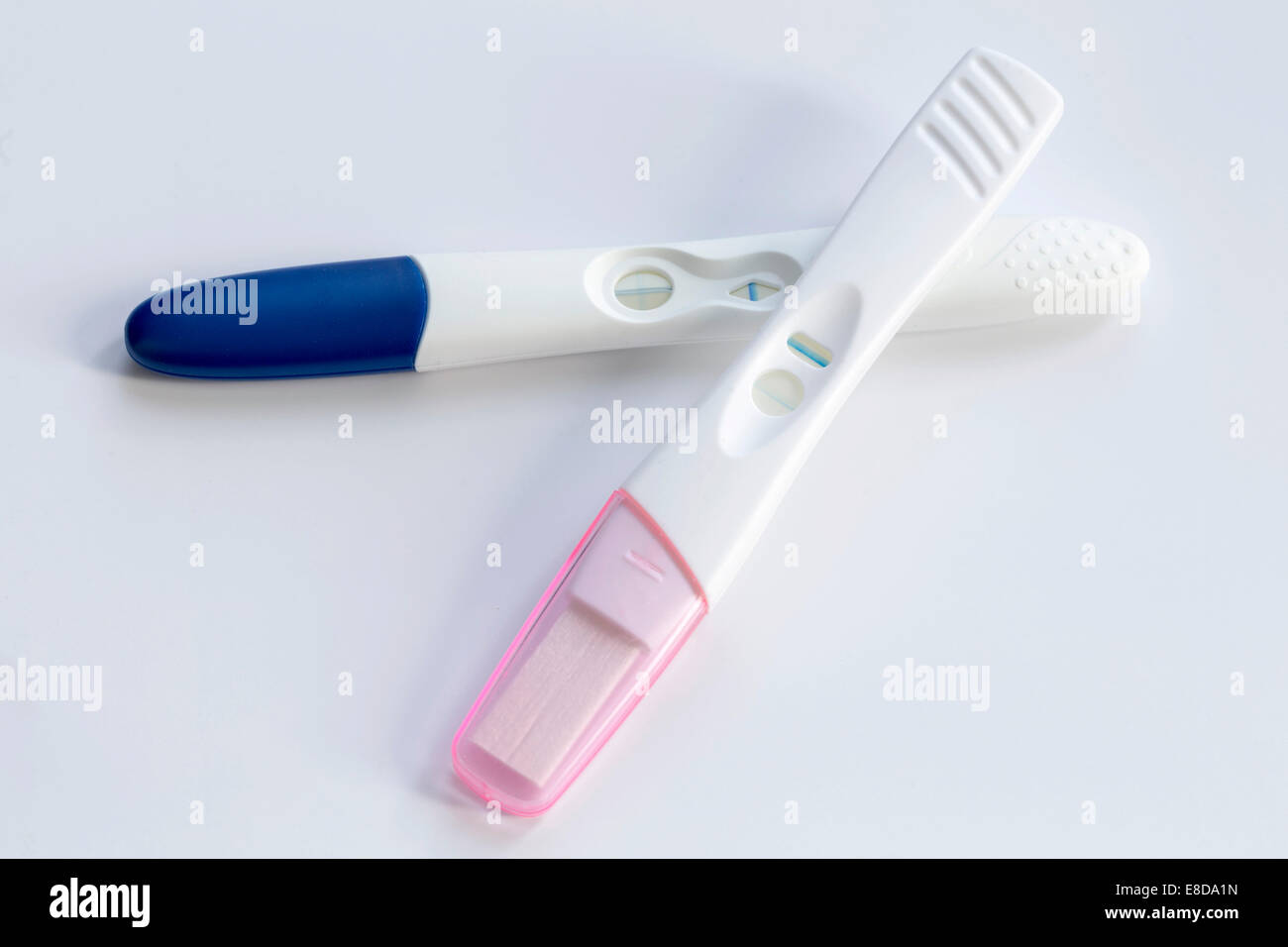 Two positive pregnancy tests, lying on top of each other Stock Photo