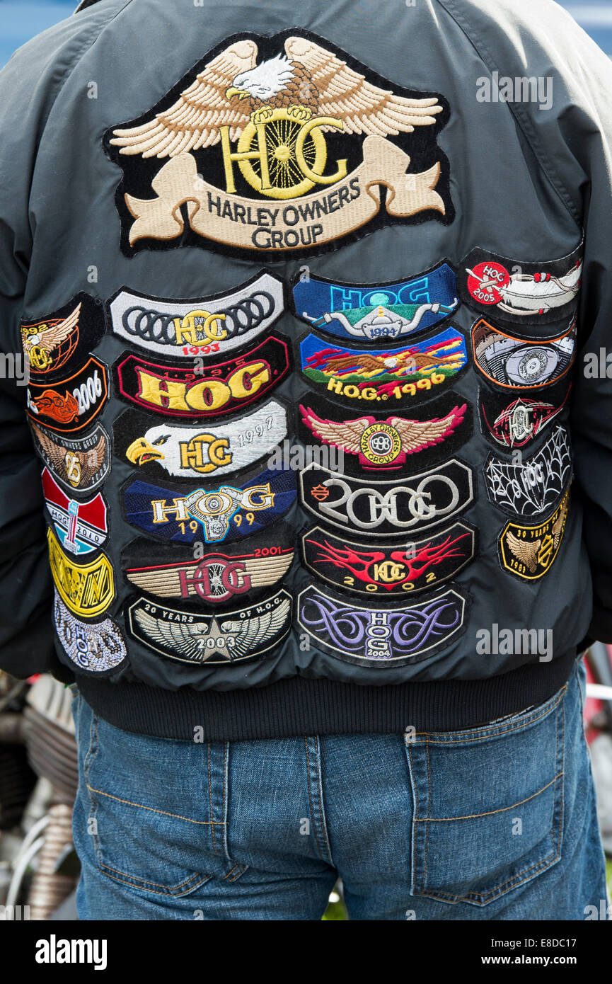 Biker wearing a leather jacket covered in Harley Owners Group badges
