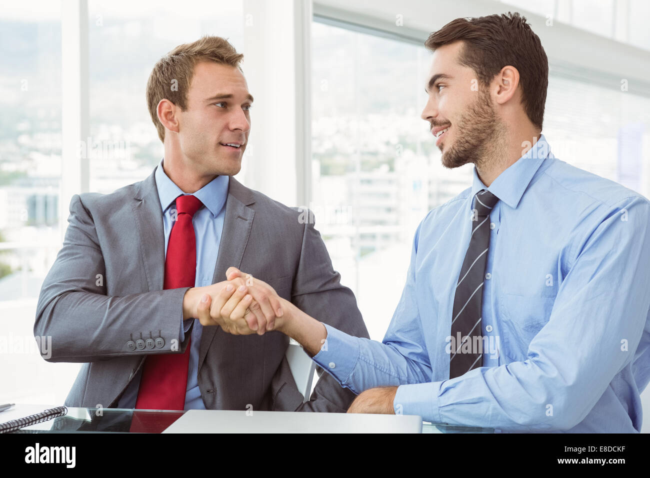 Executives shaking hands in board room meeting Stock Photo