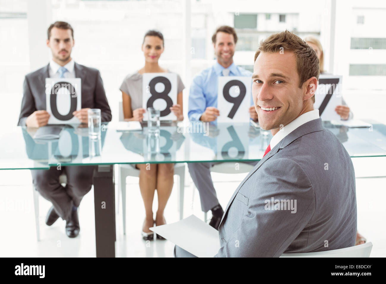 Interview panel holding score cards in office Stock Photo Alamy