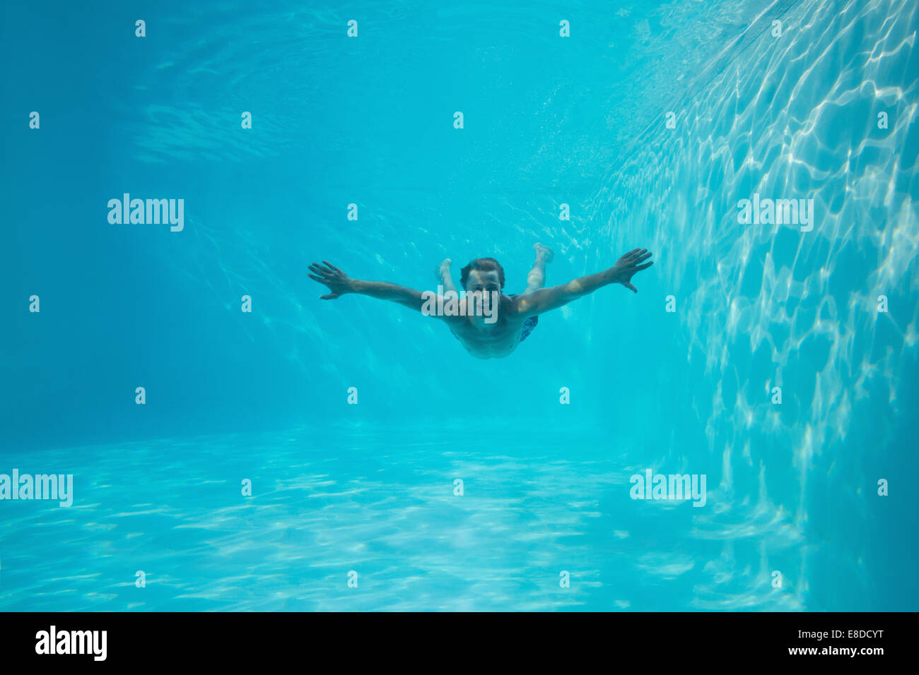 Young man swimming underwater Stock Photo