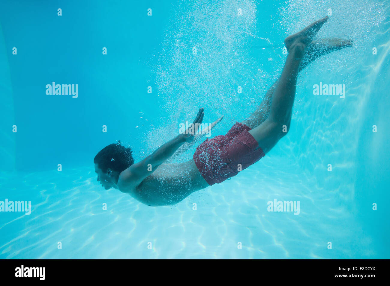 Young man swimming underwater Stock Photo