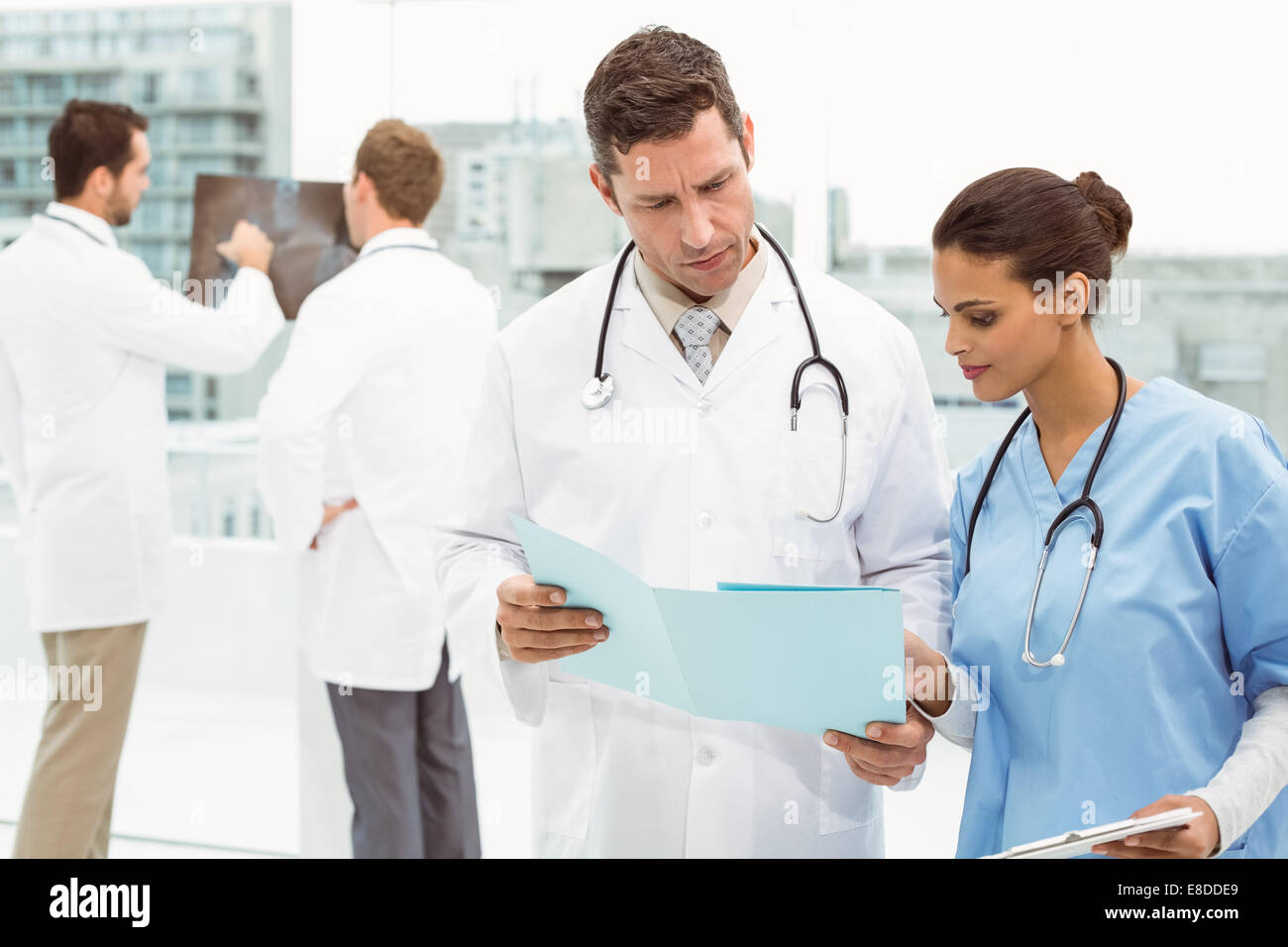 Male doctor and surgeon looking at reports Stock Photo