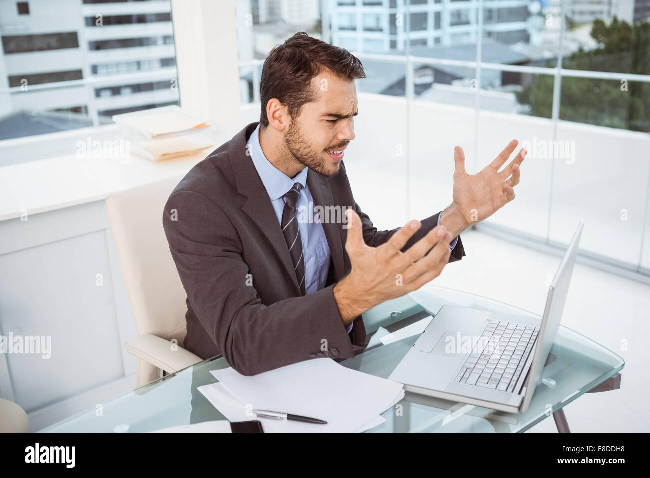 Frustrated businessman using laptop in office Stock Photo - Alamy