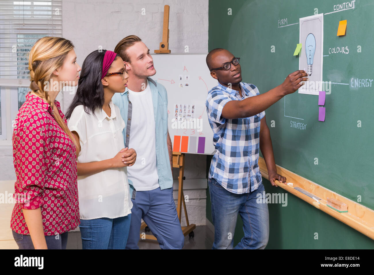 Creative business people at work by blackboard Stock Photo - Alamy