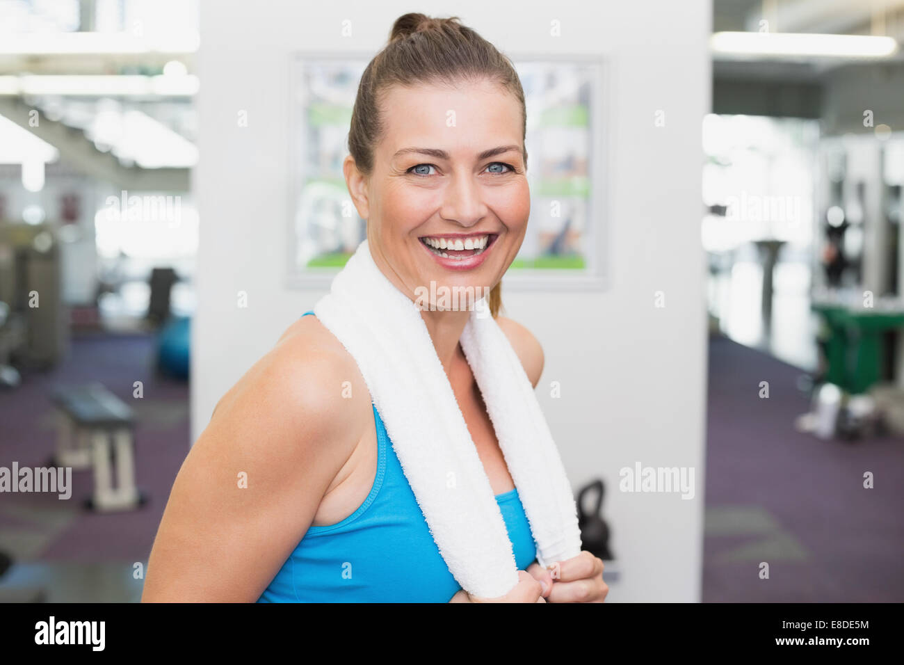 Fit brunette smiling at camera in fitness studio Stock Photo - Alamy