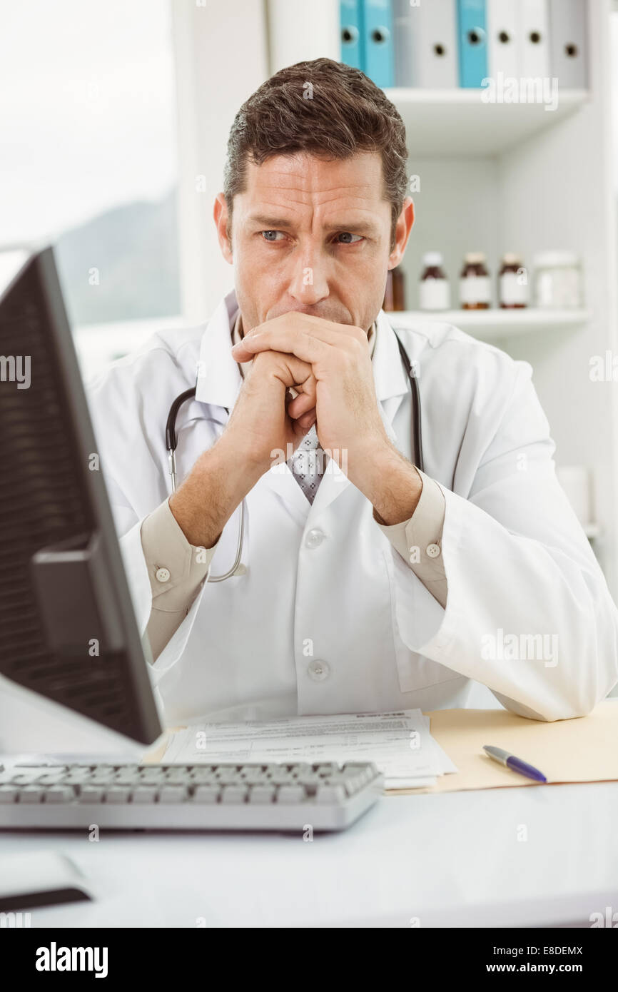 Doctor looking at computer in medical office Stock Photo
