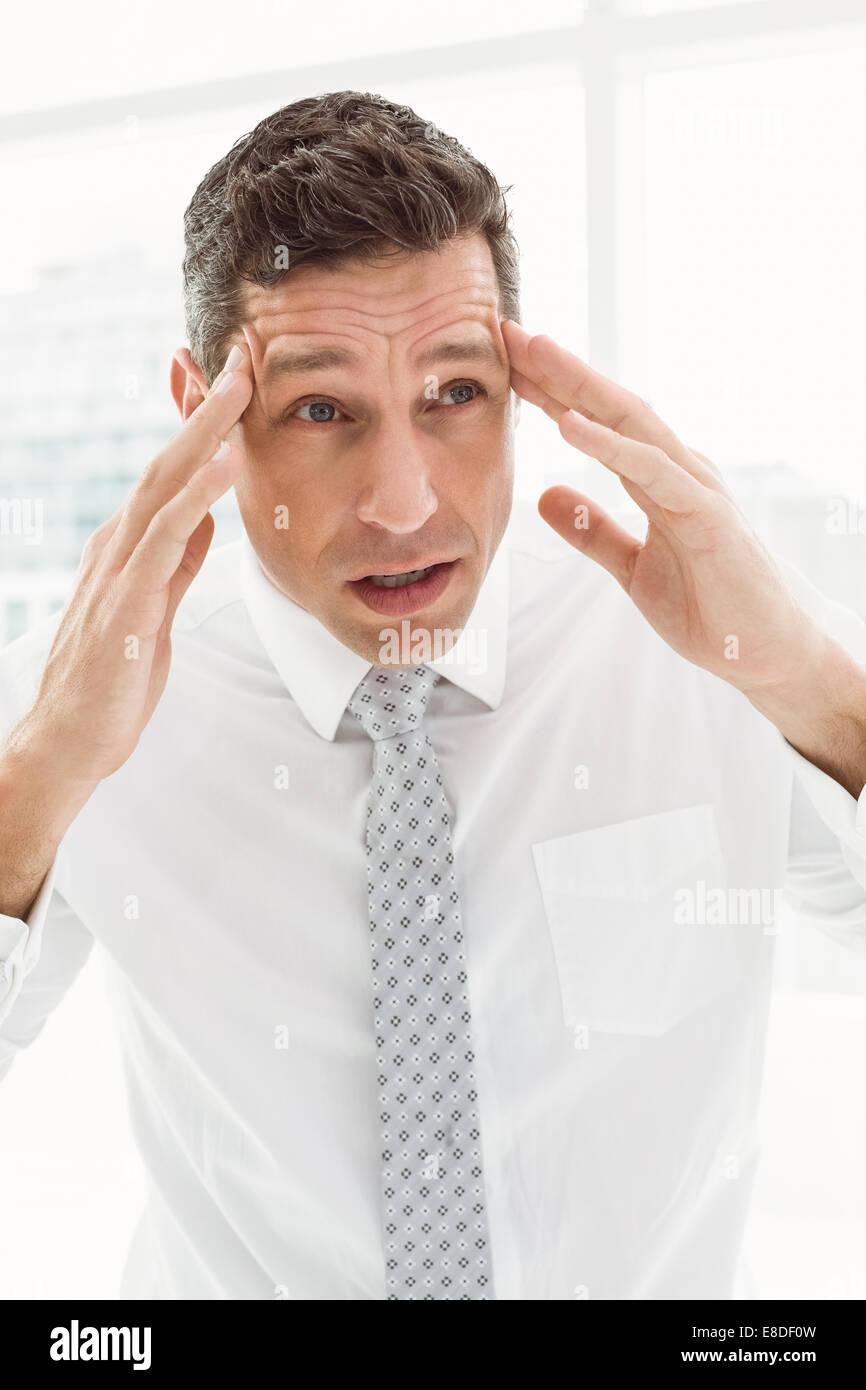 Young businessman with severe headache in office Stock Photo Alamy