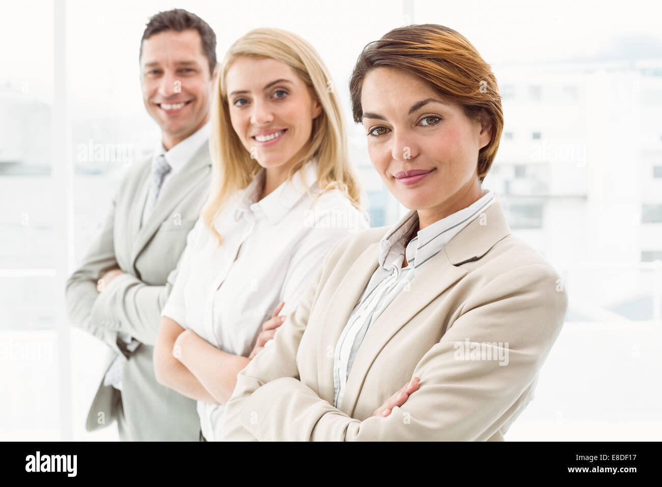 Happy business people with arms crossed in office Stock Photo - Alamy