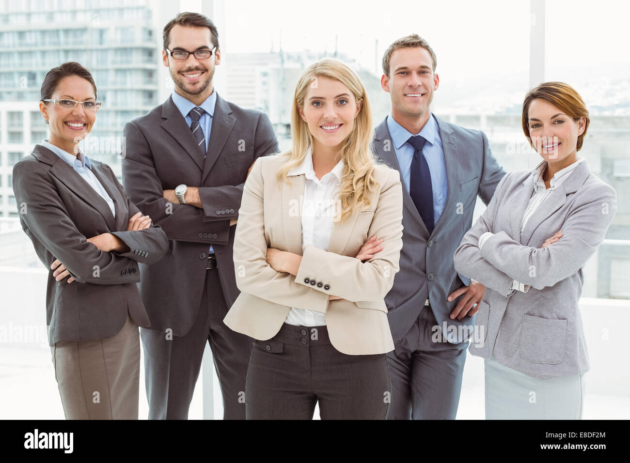 Young business people with arms crossed in office Stock Photo - Alamy