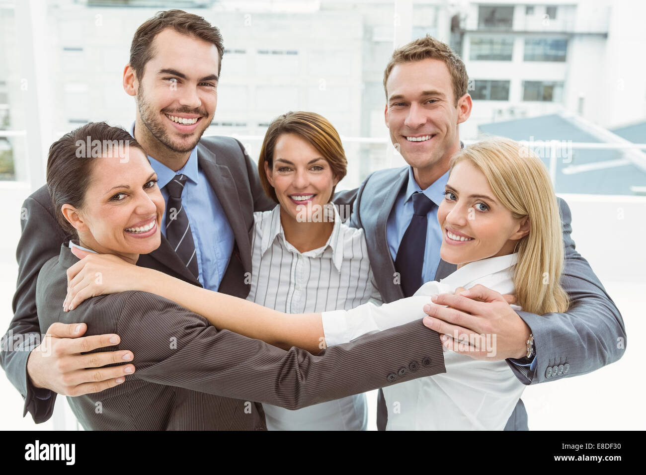 Business people with arms around in office Stock Photo - Alamy