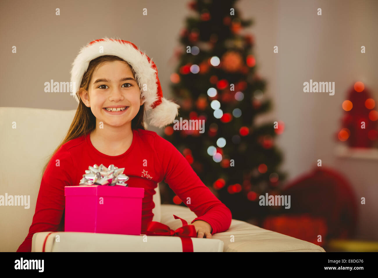 Festive little girl smiling at camera with gifts Stock Photo - Alamy