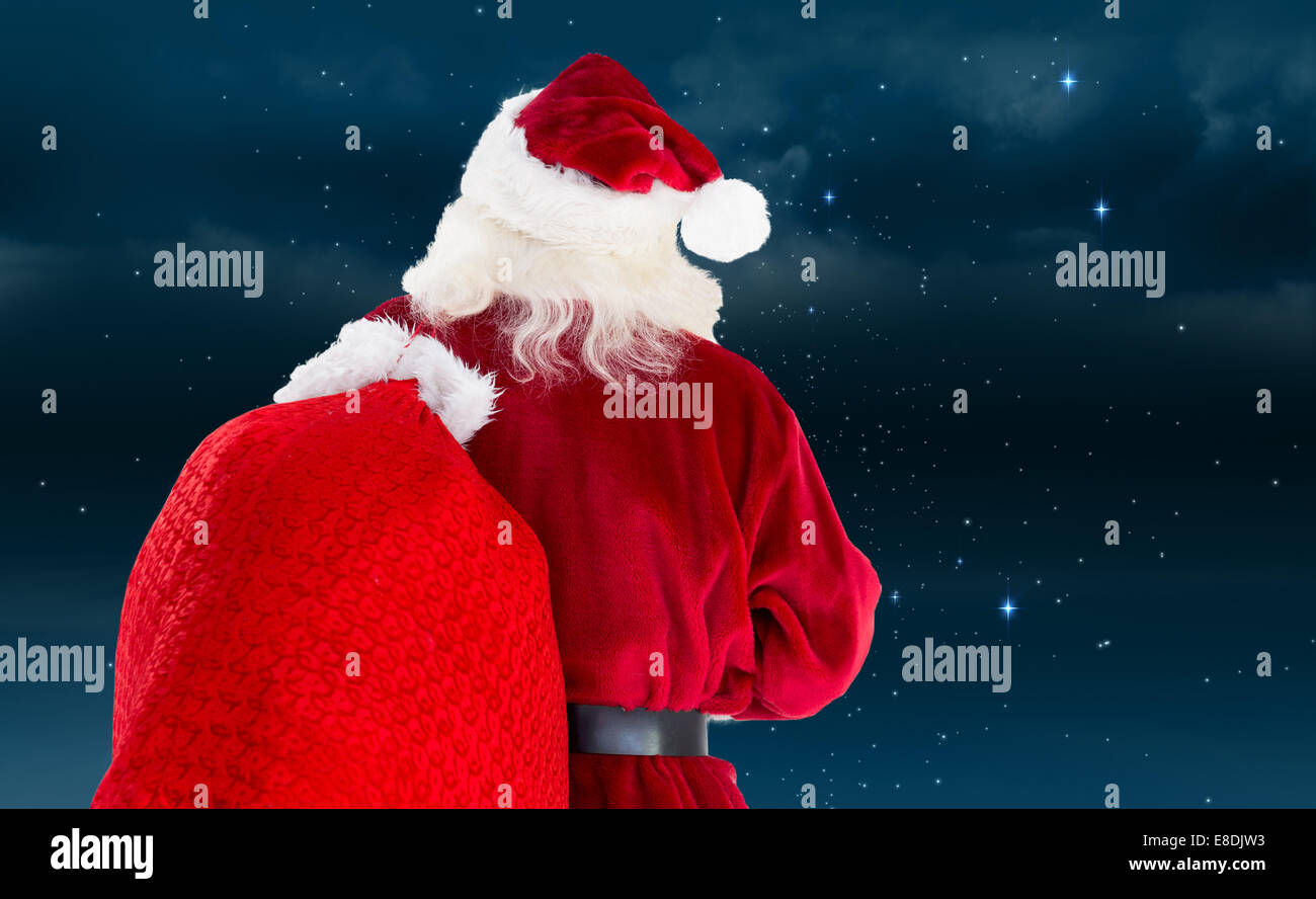 Composite image of santa claus carrying sack Stock Photo - Alamy