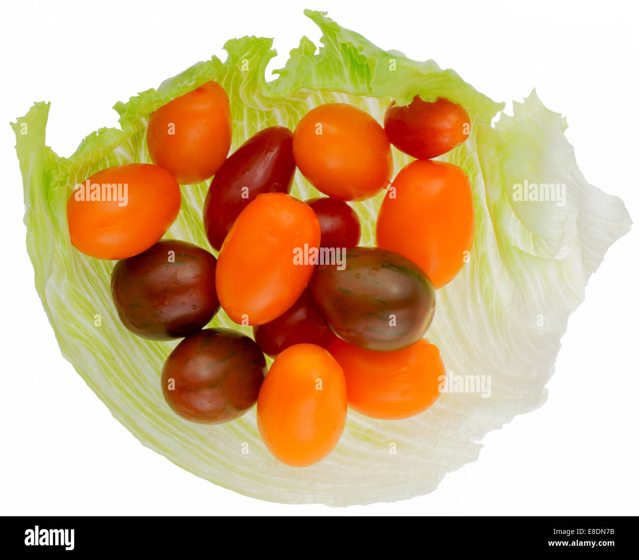 Different colored cherry tomato in lettuce on a white back ground Stock Photo