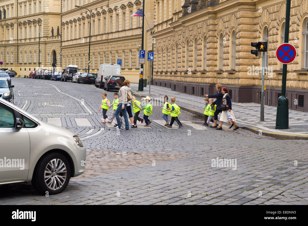 PRAGUE, CZECH REPUBLIC - SEPTEMBER 06, 2014: Kindergarden children wearing yellow safety vests while crossing the street in Prag Stock Photo