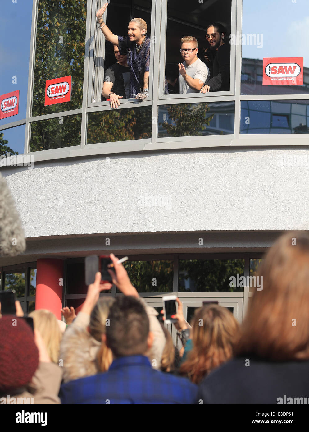 Magdeburg, Germany. 05th Oct, 2014. Musicians Georg Listing (L-R), Bill Kaulitz, Gustav Schaefer, and Tom Kaulitz of the band 'Tokio Hotel' wave their fans after a listening concert at the radio station SAW in Magdeburg, Germany, 05 October 2014. Photo: Jens Wolf/dpa/Alamy Live News Stock Photo