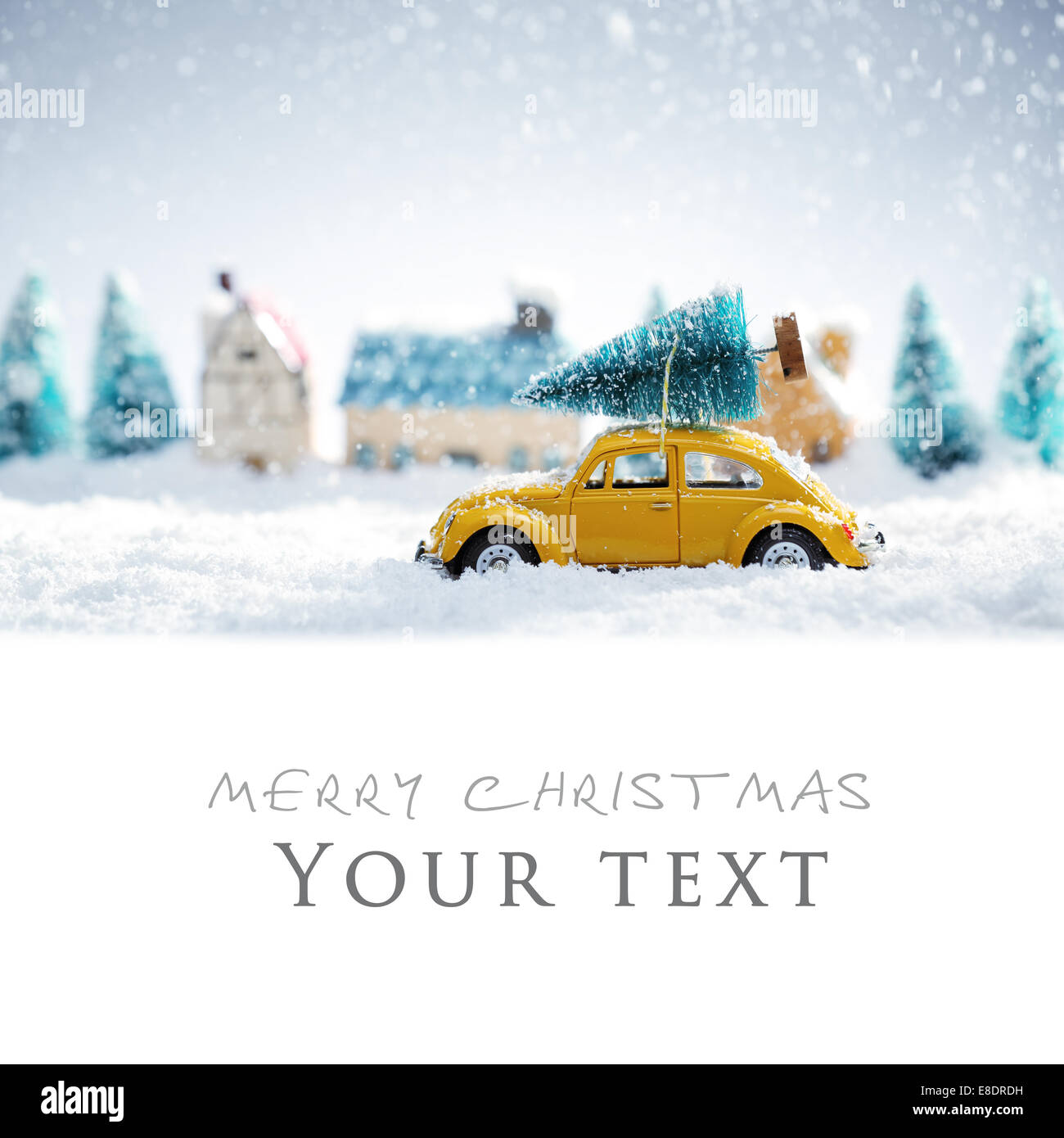Miniature yellow car with fir tree on snow Stock Photo
