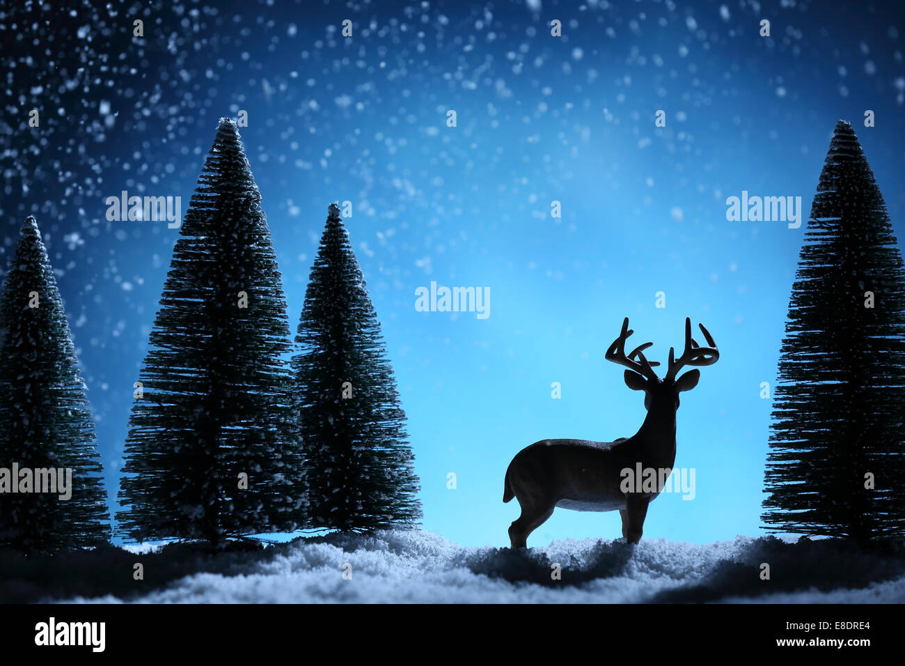 Silhouette of deers and fir tree on Christmas background. Stock Photo