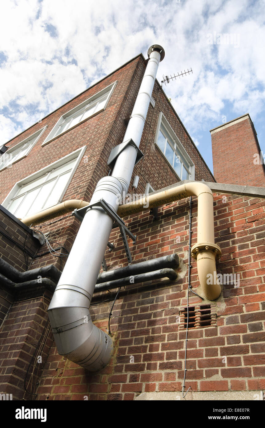 metal flue and chimney with steel heating pipes on outside of brick