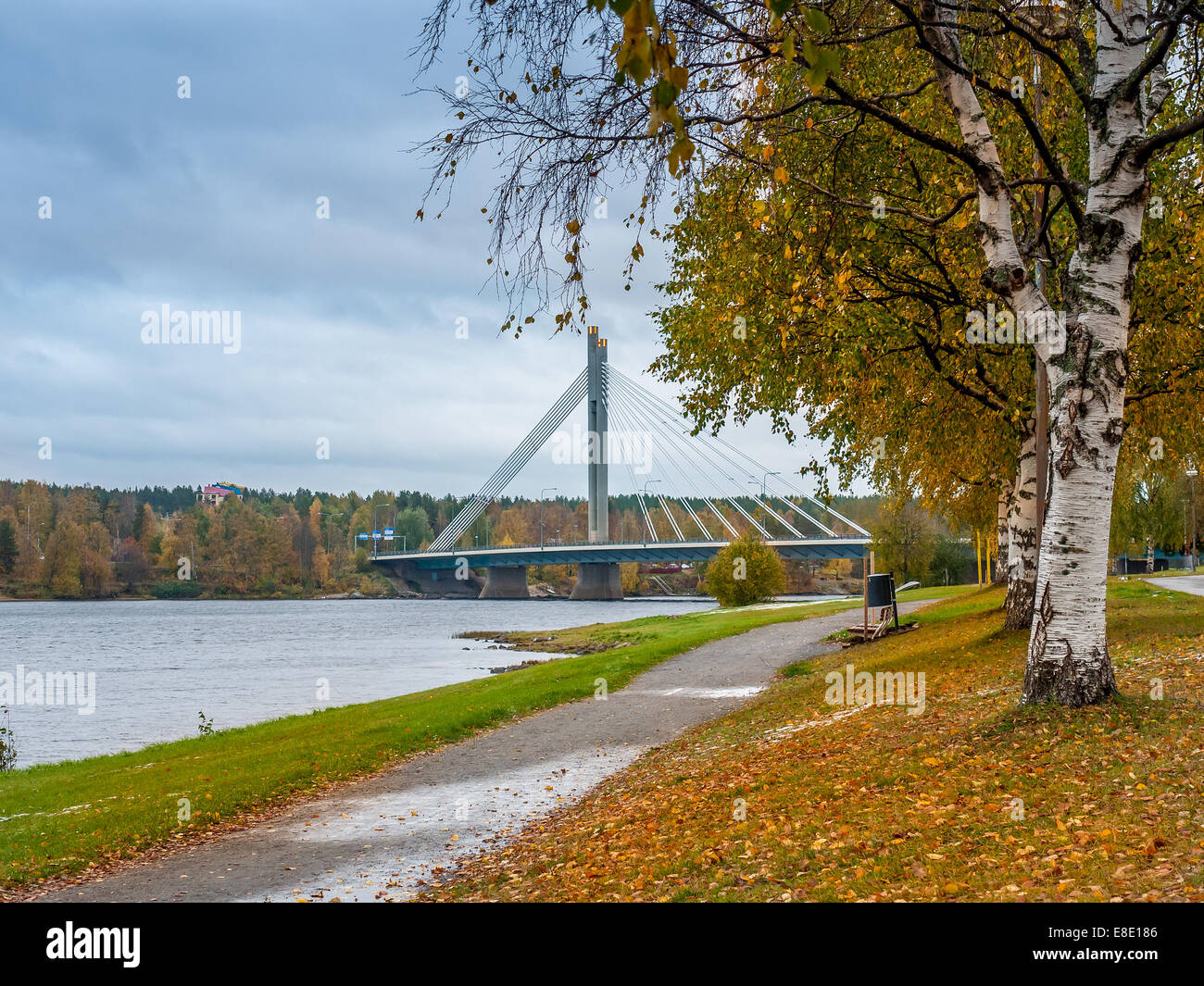 Park alley in autumn colors with bridge over the river in the background, Rovaniemi, Finland Stock Photo