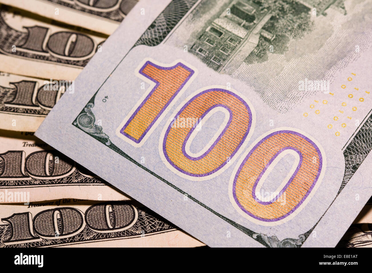 Many Hundred Dollar bills spread on a table top showing several different types of security printing techniques Stock Photo