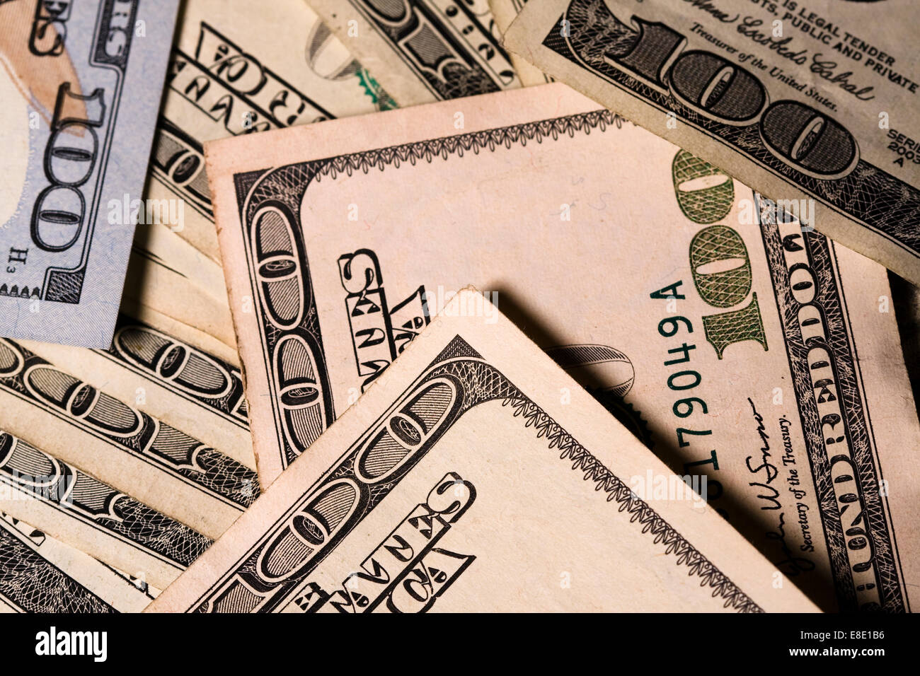 Many Hundred Dollar bills spread out on a table top Stock Photo