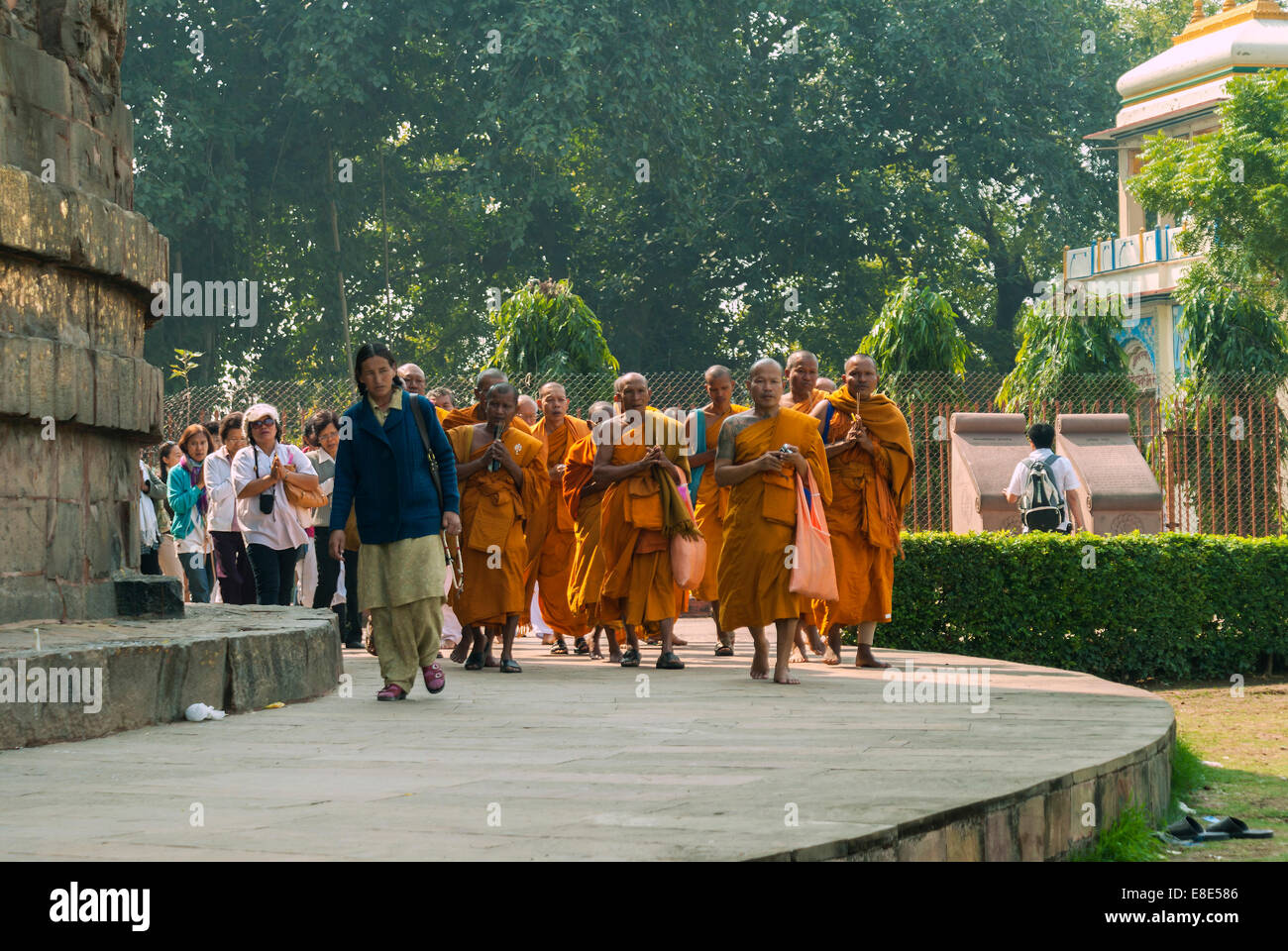 Buddhist monks, followed by pilgrims, circle the Dhamekh Stupa. Stock Photo
