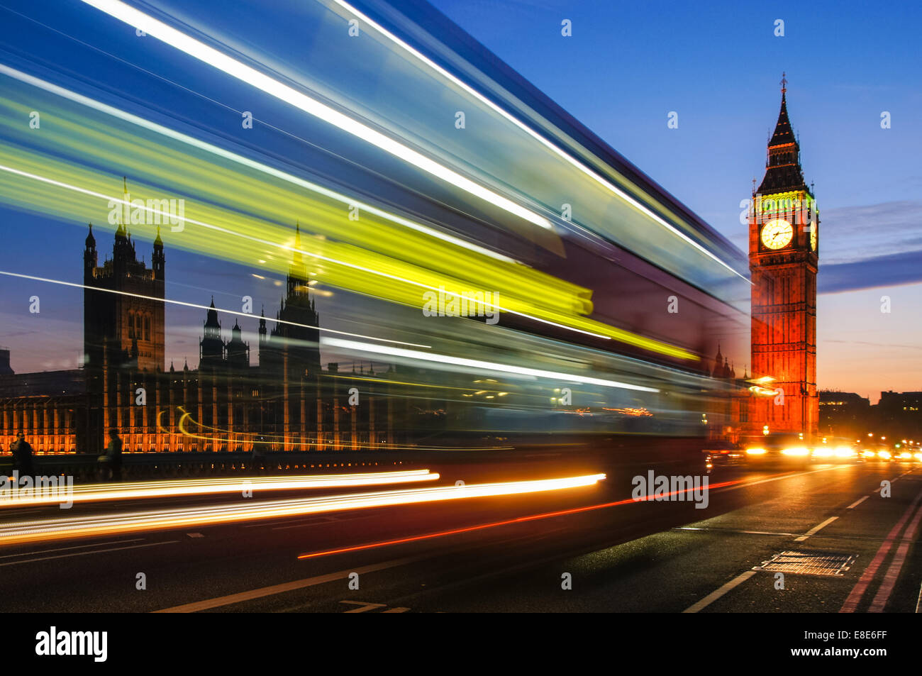 Light trails left by double decker bus passing by Big Ben in London England United Kingdom UK Stock Photo